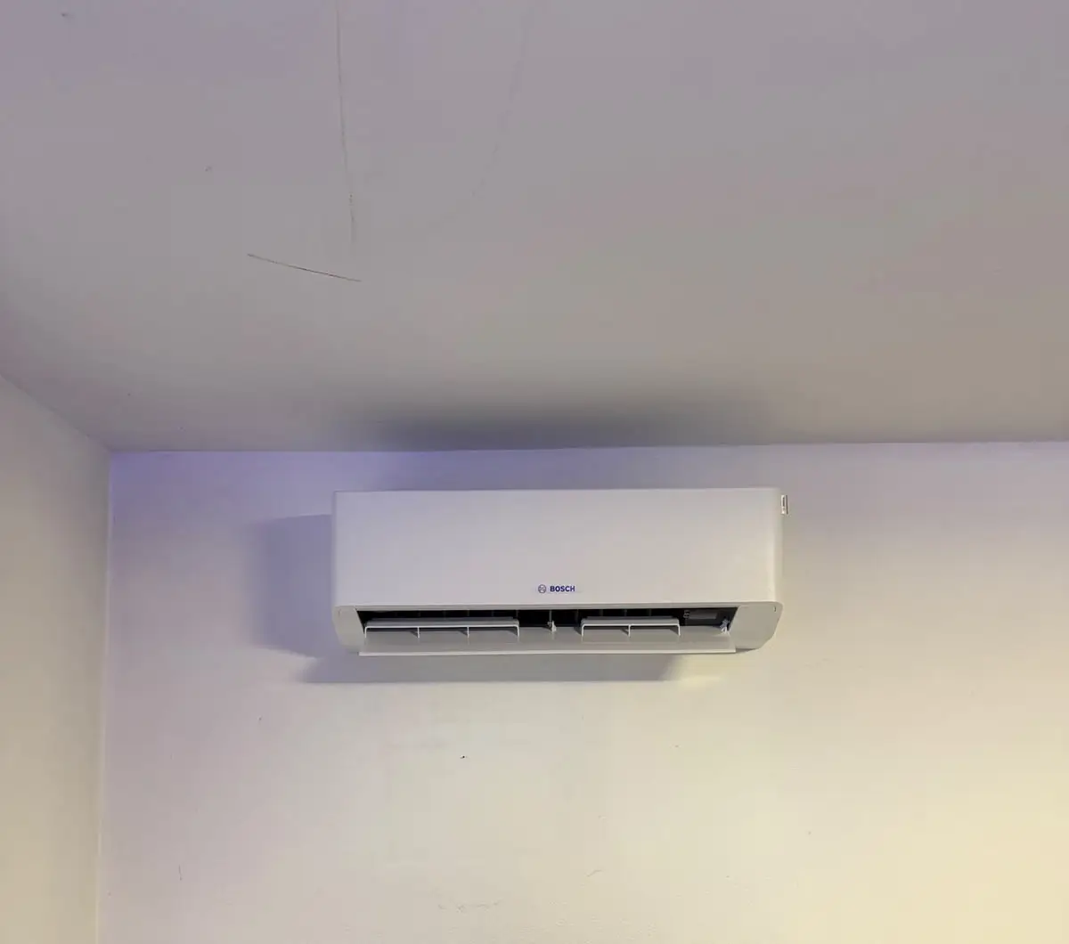Innengerät von Bosch an der Wand eines Arbeitszimmers, dicht unter der Decke.